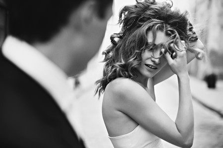 Man watches a woman playing with her hairの写真素材