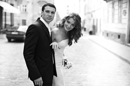 Bride looks round at the groom while wlaking around the cityの写真素材