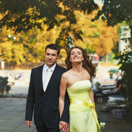 Man and lady in yellow face pose holding their hands togetherの写真素材