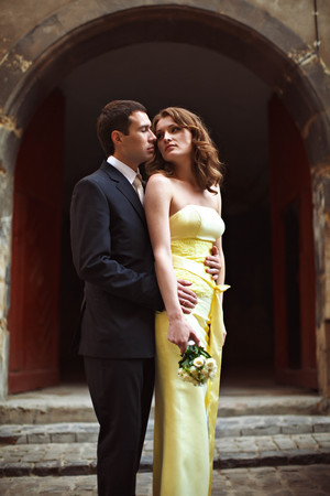 Man in black suit holds elegant lady in yellow dressの写真素材