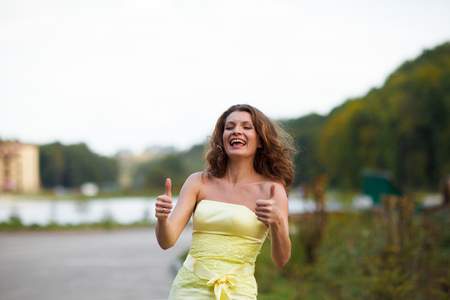 Woman smiles holding her tumbs upの写真素材