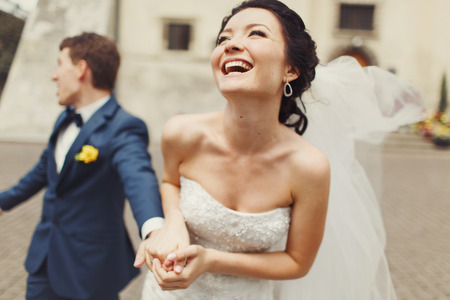 Bride laugh sparkling holding groom's handの写真素材