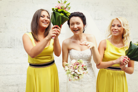 Bride and girls have fun posing with a bouquetsの写真素材