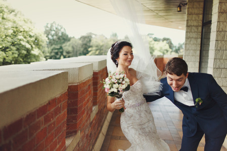 Newlyweds have fun on the brick balconyの写真素材