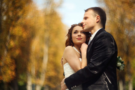 High hopes - wedding couple stands in an autumn parkの写真素材