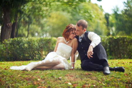 Trust and hug - wedding couple rests on the green groundの写真素材