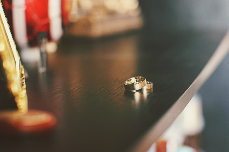 Wedding rings lie and sparkle on a dressing tableの写真素材