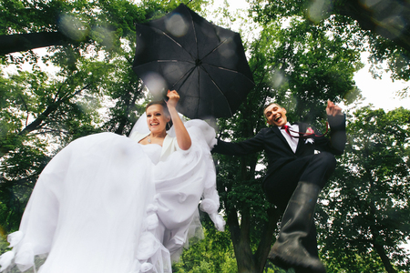 Bride and groom jump like a children in poolsの写真素材