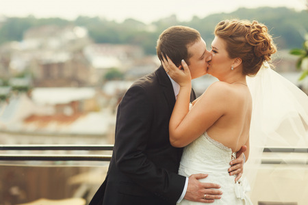 Groom kisses bride after a wedding ceremonyの写真素材