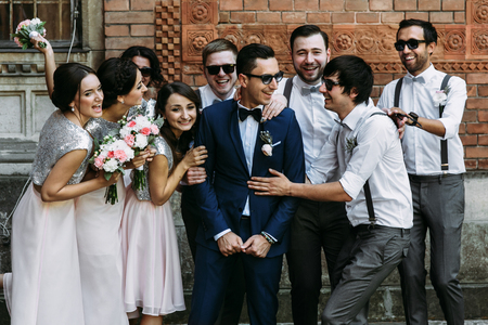 Groom surrounded by bridesmaids and groomsmenの写真素材