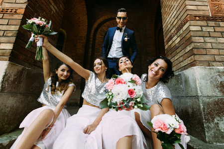 Groom with the charming bridesmaids with the bouquetsの写真素材