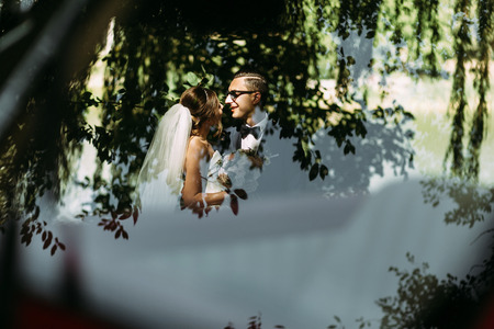 Reflection of the lovely couple next to the carの写真素材