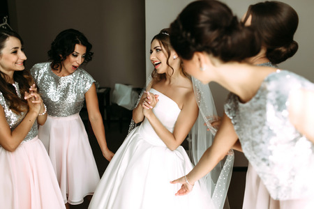 Bridesmaids are looking at the beautiful brideの写真素材