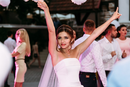 Bride with the hands up on the dance floorの写真素材