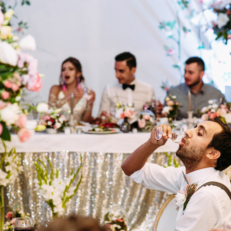 Guest is drinking alcohol in front of a coupleの写真素材