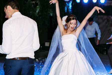 Funny moves of the bride in the veil on the weddingの写真素材