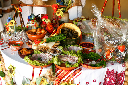 Pickled vegetables and cut meat lie on the table decorated in ethnic styleの写真素材