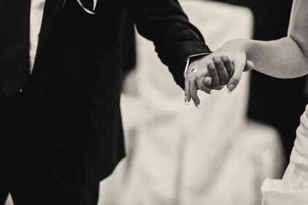 A close-up of tender bride's arm held by a groomの写真素材