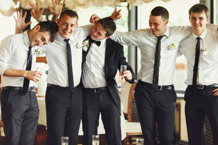 Groom and groomsmen have fun while posing in the restaurantの写真素材