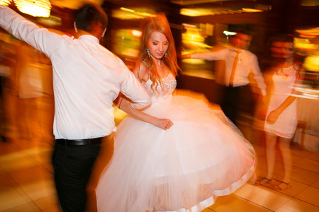 Bride and groom dance in a yellow disco lightの写真素材