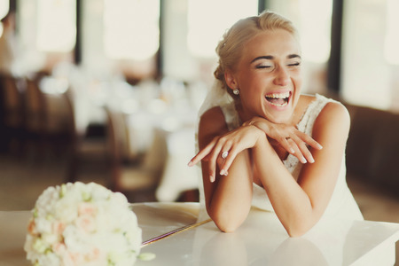 Bride laugh broad sitting at a white pianoの写真素材