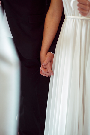 Close-up of newlweds hands holding each other tightlyの写真素材