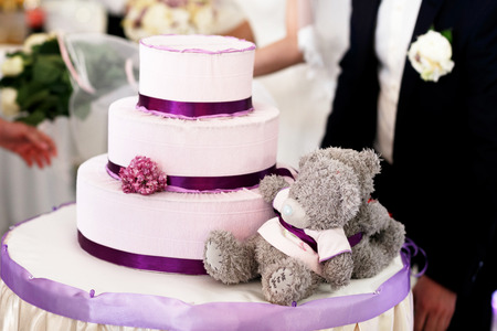 Gray Teddy-bears lie behind a wedding cakeの写真素材