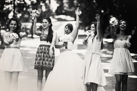 Black and white photo of dancing bride and bridesmaids in the parkの写真素材