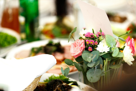 Little bouqets stand in vases with water on the tableの写真素材