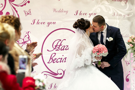 The brides kissing  near wedding bannerの写真素材