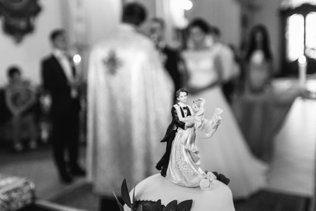 Figures of newlyweds standing on the top of a wedding cakeの写真素材