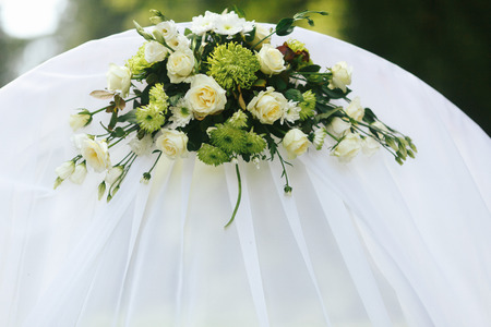 Green and white bouquet beautifies a white wedding altarの写真素材