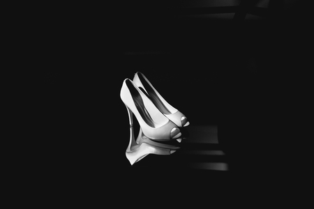 Tender white shoes stand in a black roomの写真素材