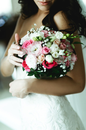 A closeup of a bouquet in tender bride's handsの写真素材