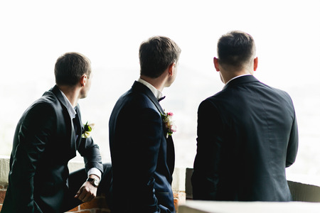 Groom and groomsmen stand on the balconyの写真素材