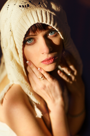 Woman in a shawl looks up with her deep blue eyesの写真素材