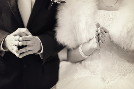 Newlyweds hold their hands for a prayerの写真素材