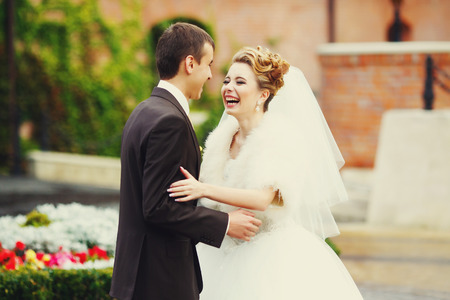 Bride smiles greeting a groom outside the hotelの写真素材