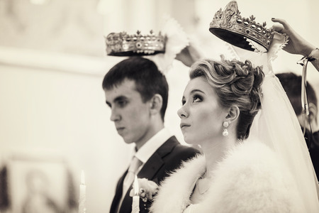 Bride looks up on the crown held over herの写真素材