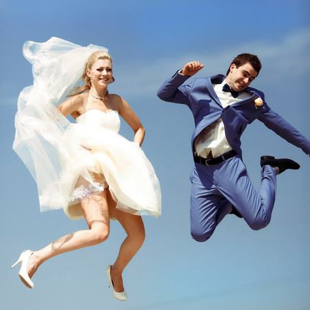 Couple jumps in the sky in the wedding dayの写真素材