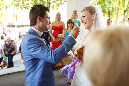 Groom feeds his bride with a   wedding breadの写真素材