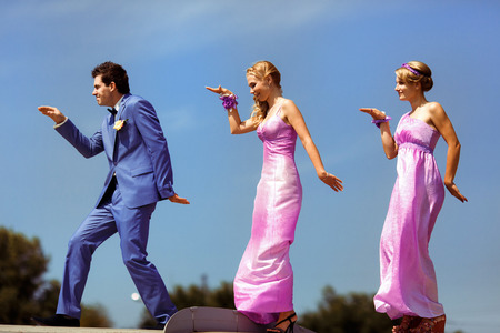 Funny groom with the two bridesmaidsの写真素材