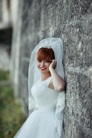 The charming bride stands near wallの写真素材