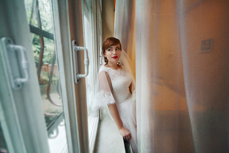 The charming bride looks at windowの写真素材