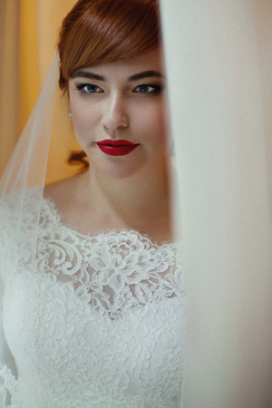 The charming bride looks at windowの写真素材