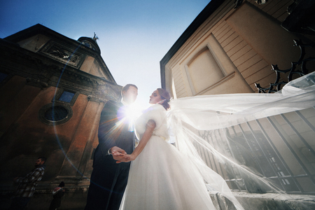 The charming couple in love stand in the center of townの写真素材