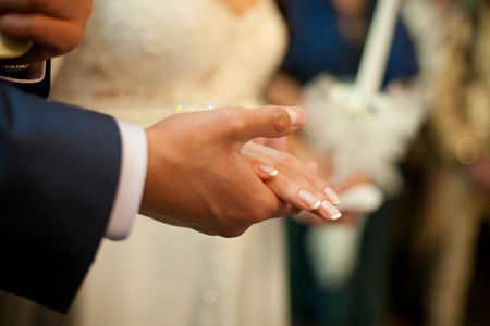 Groom's hand holds bride's palm delicatelyの写真素材