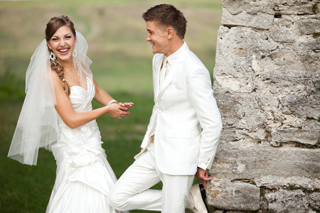 Laughing bride stands in the front of a groomの写真素材