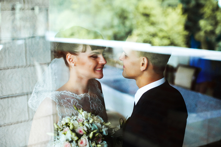 A look through the glass on a pretty bride with brunette hair smiling to a groomの写真素材