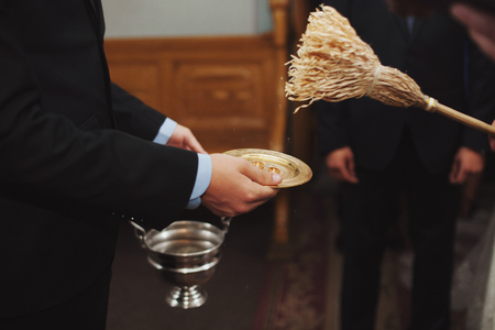 Priest blesses wedding rings lying on the bronze plateの写真素材